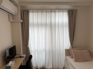 A room with a bed, a desk with a computer, and a window with curtains. - Y207 Monthly Rental Tokyo - Yoga Single Telework (Setagaya City)