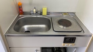 A compact kitchen with a sink, a small stove, and a dishwasher. - Y303 - Sunshine Yoga (Setagaya City)