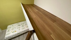 A room with a wooden floor, a green wall, and a white ceiling. - Y303 - Sunshine Yoga (Setagaya City)