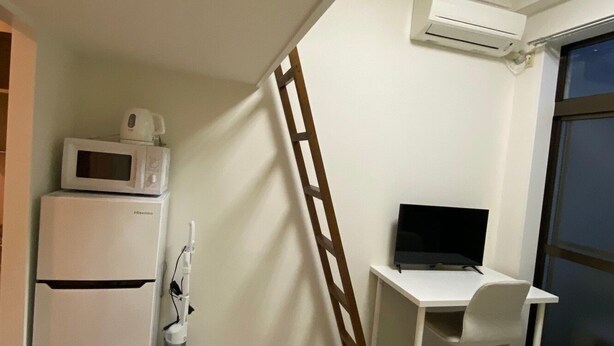 A compact room with a kitchenette, a desk with a computer, a ladder, and a large window. - Y303 - Sunshine Yoga (Setagaya City)