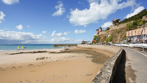A beach with a stone wall, a clear sky, and a distant castle. - 130m from the beach, nice flat for 4 (Pléneuf-Val-André)