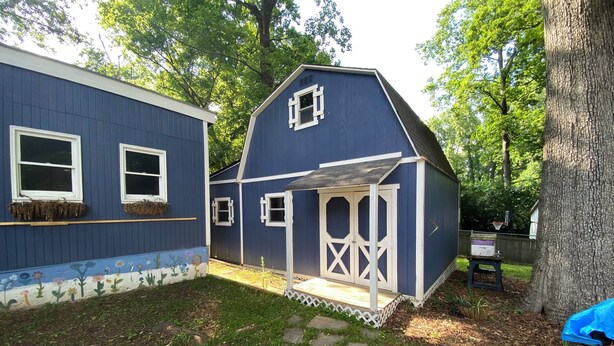 Ein blaues Haus mit Veranda und kleinem Garten.