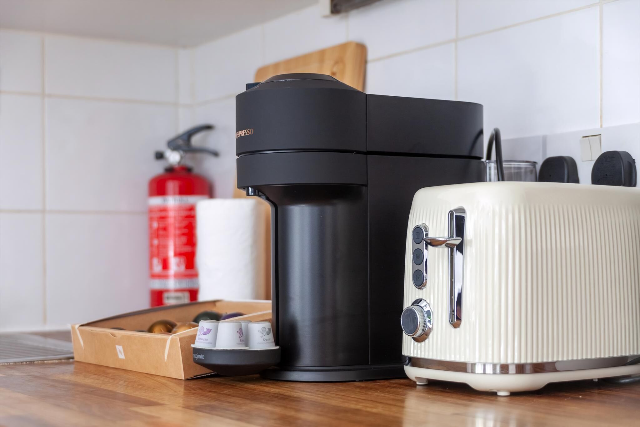 A kitchen with a coffee maker, toaster, and a fire extinguisher.