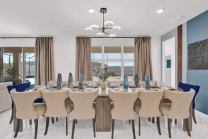 Un comedor moderno con una mesa redonda, sillas color beige y un centro de mesa decorativo.