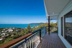 A balcony with a view of the ocean and a residential area. - The Lighthouse: Poolside Oceanview Infinity (Airlie Beach)