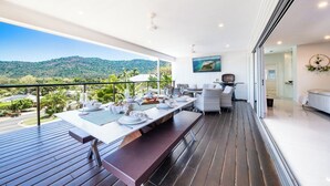 Un comedor con una mesa preparada para cuatro, un sofá y una televisión.