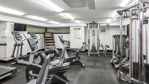 A gym with various exercise equipment including treadmills, elliptical machines, and weight machines. - Island Haven Hawaiian Monarch Studio | Ocean View (Honolulu)