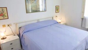 Una camera da letto con un letto singolo, due comodini e un'opera d'arte appesa al muro.
