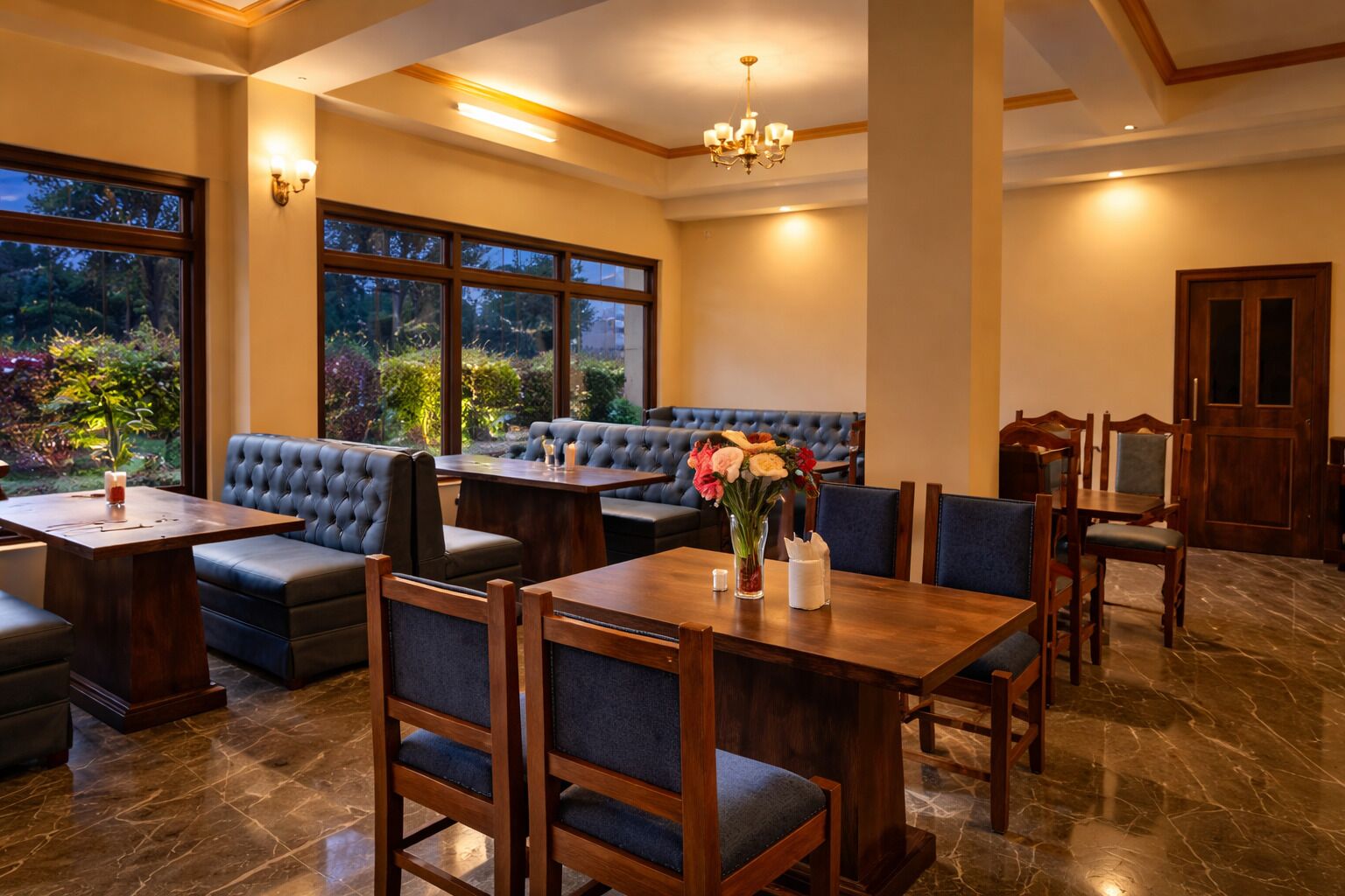 A restaurant with a dining area, booths, and a view of the outdoors.