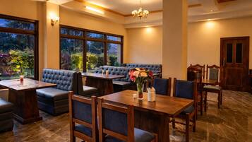 A restaurant with a dining area, booths, and a view of the outdoors.