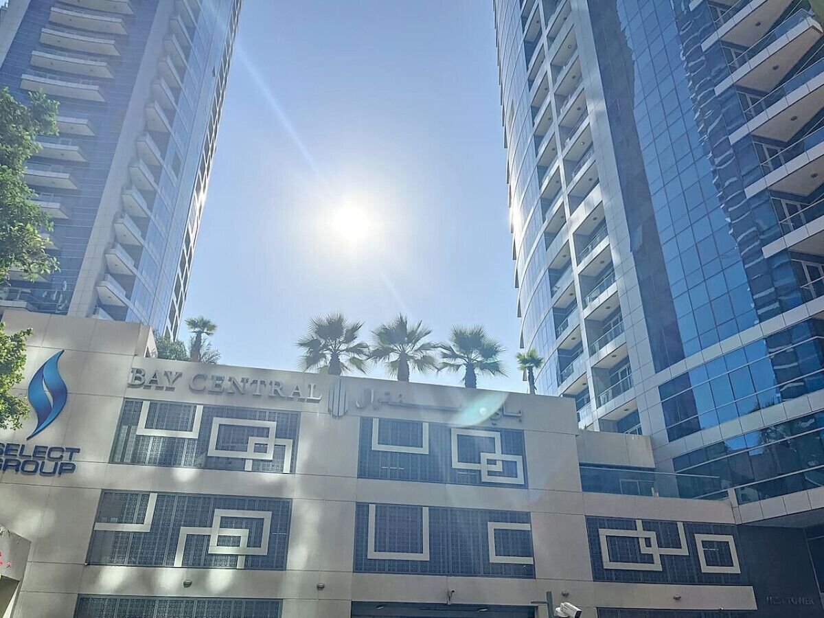A multi-story building with the sign "Bay Central Hotel" and "Select Group" logos.