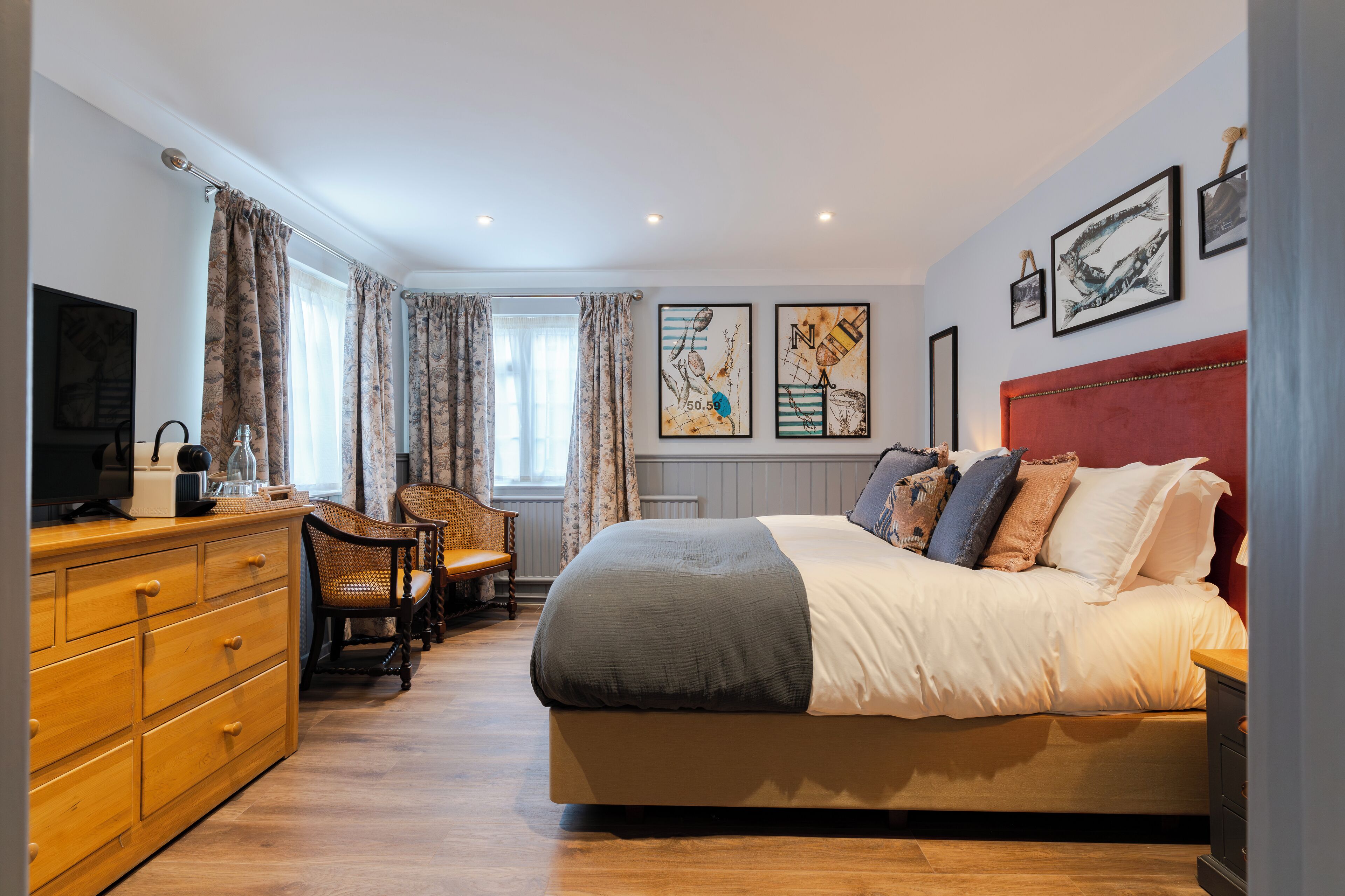 A bedroom with a bed, a desk, a chair, and a television.