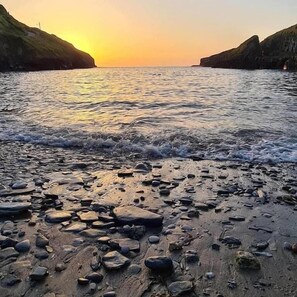 A rocky beach with waves at sunset. - Port Gaverne Hotel (Port Isaac)