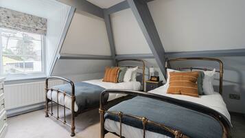 Une chambre avec deux lits, une commode et une fenêtre donnant sur un beau paysage.
