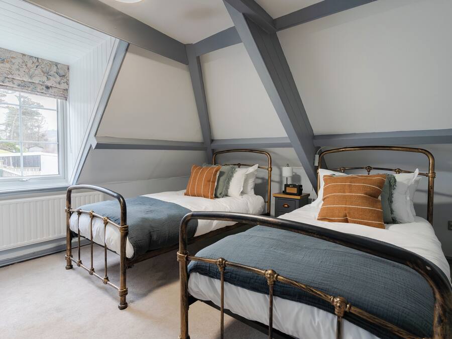 Une chambre avec deux lits, une commode et une fenêtre donnant sur un beau paysage.