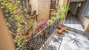 A narrow outdoor corridor with potted plants along a metal railing, a checkered floor, and a staircase in the background. - Historic center of Rome, 2 steps from the Colosseum (Roma)