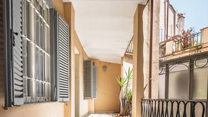 A corridor with checkered flooring, a potted plant, and a metal railing. - Historic center of Rome, 2 steps from the Colosseum (Roma)