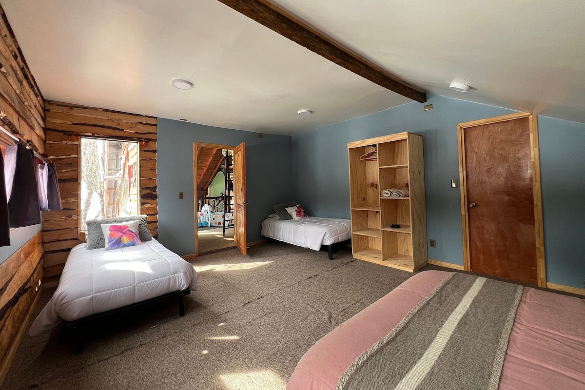 Een kamer met een bed, een houten garderobe en een deur.