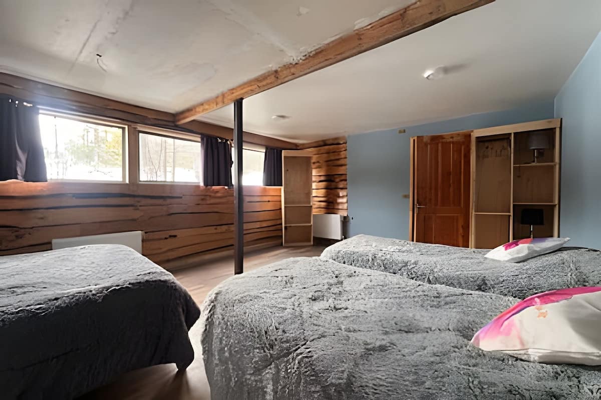 Een kamer met houten wanden, een bed, een kledingkast en een raam.