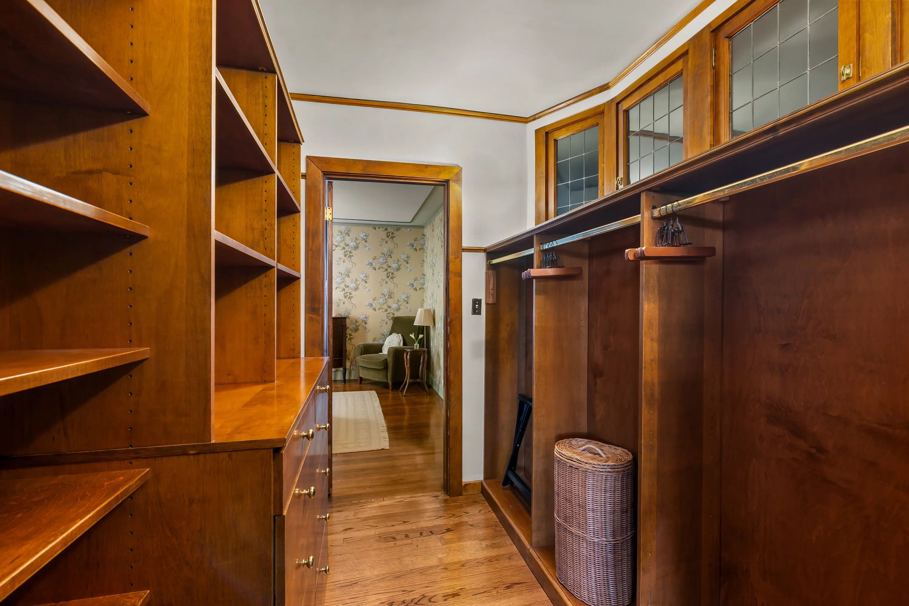 A wooden hallway with built-in shelving and a wicker basket.