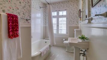 A bathroom with a bathtub, toilet, and sink.