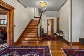Grand staircase with original wood banister and chandelier. - The Coulter House by Gather: Historic San Diego Estate w/ Ocean Views (San Diego)
