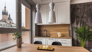 A modern kitchen with white cabinets, a wooden countertop, and a large window. - Feniks Stunning 2-bed apartment with 3 terraces (Kraków - Feniks)