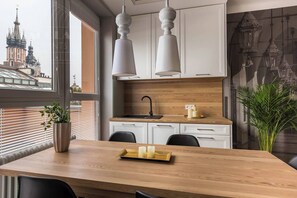 Una cocina moderna con armarios blancos, encimera de madera y un ventanal grande.