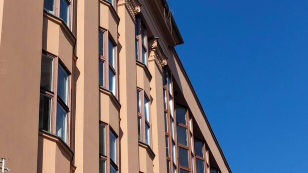 A multi-story building with a series of windows and a corner entrance. - Feniks Stunning 2-bed apartment with 3 terraces (Kraków - Feniks)