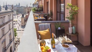 A balcony with a table set for a meal, a bottle of wine, and a view of the cityscape. - Feniks Stunning 2-bed apartment with 3 terraces (Kraków - Feniks)