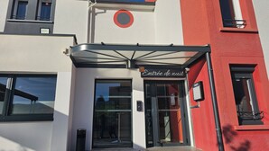 A building with a sign reading "Entrée de nuit" indicating a night entrance.