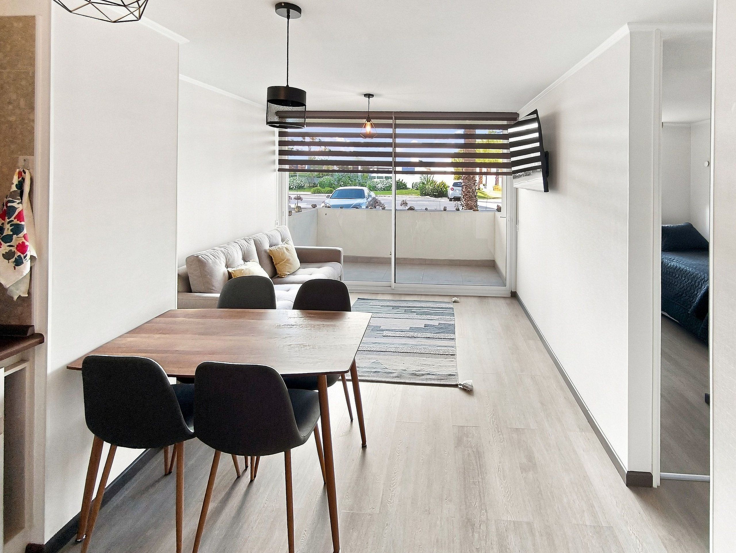 Un intérieur moderne comprenant un coin repas, un canapé et une vue à travers une porte coulissante.