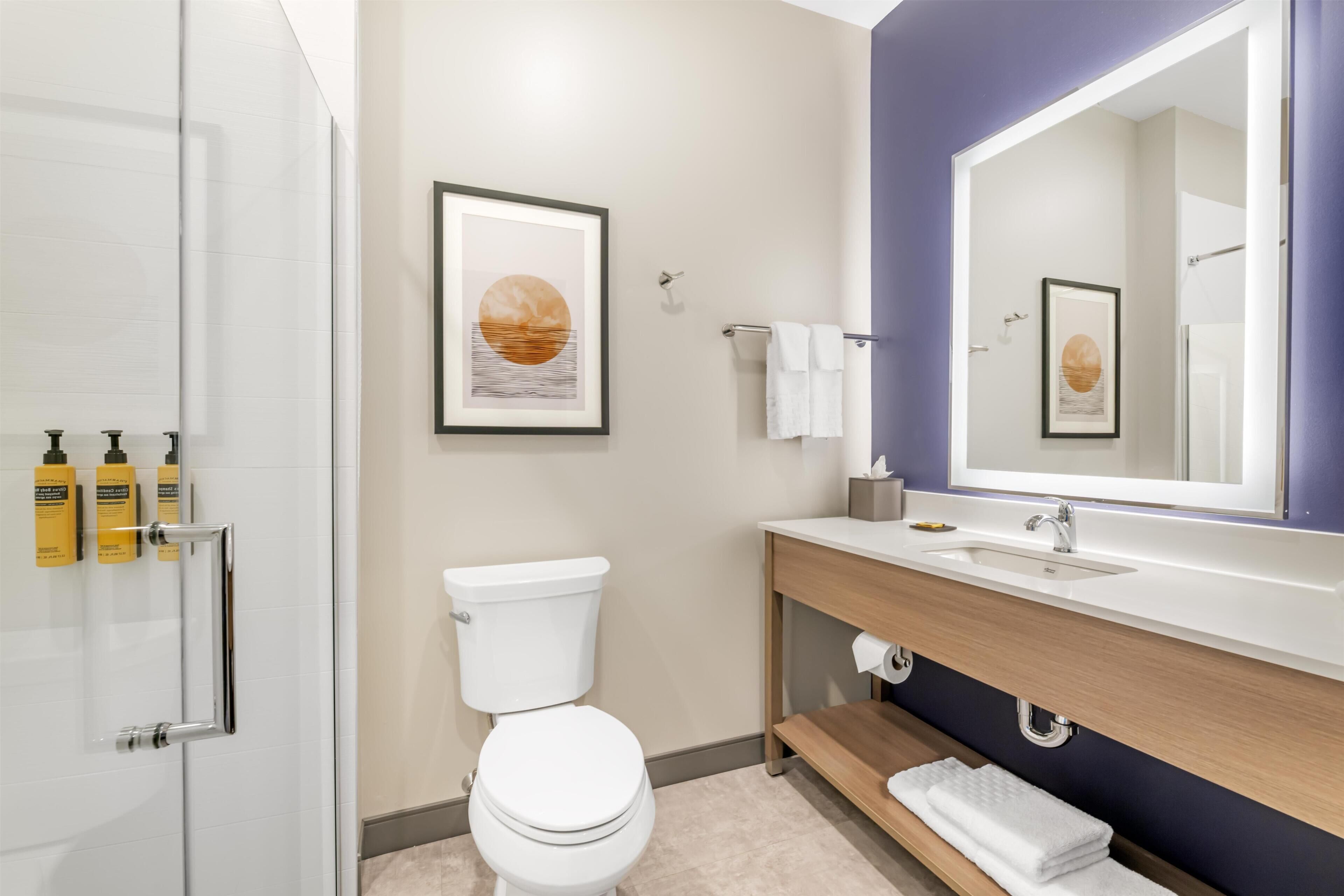Et moderne badeværelse med toilet, vask og brusebad.