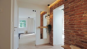 Un intérieur moderne avec un mur en briques, un grand miroir et un banc en bois.