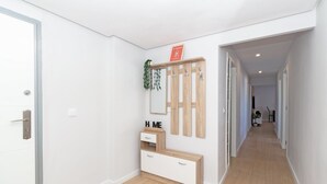 Ein Flur mit einer hölzernen Bank, einem Spiegel und einem Schild mit der Aufschrift 'HOME'.