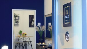 Une pièce comprenant un coin repas, un miroir et un mur orné d’un tableau et d’un numéro.