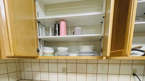Keittiössä on puiset kaapit, laatoitettu välitila ja laatikkojärjestelmä, jossa on tilaa keittiövälineille.