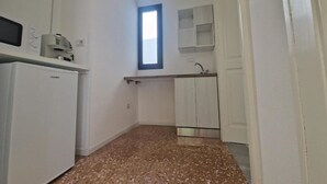 Una cocina compacta con refrigerador, pileta y ventana.
