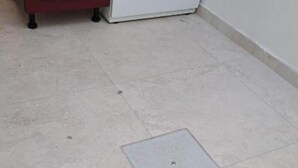 Un baño con un lavabo blanco, una silla roja y un inodoro blanco.