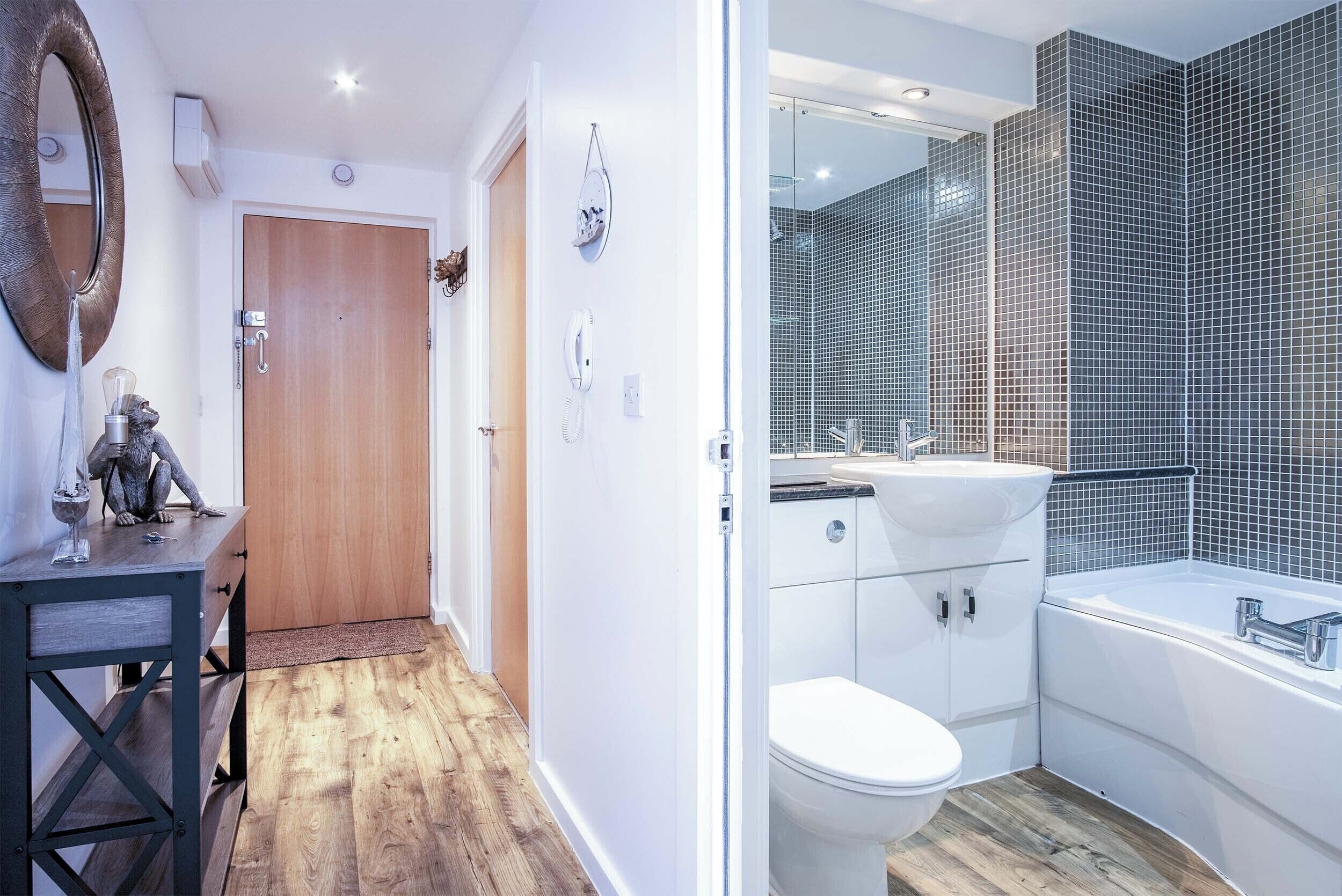 A modern bathroom with a white toilet, a sink, and a bathtub.