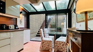 Une cuisine avec coin repas, dotée d’un mur en verre, d’un escalier et offrant une vue sur l’extérieur.