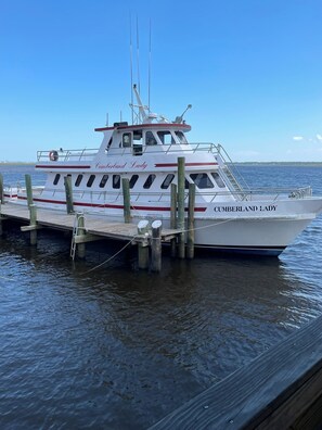 Docked at the pier, the Cumberland Lady offers a cabin with windows and a small deck area.