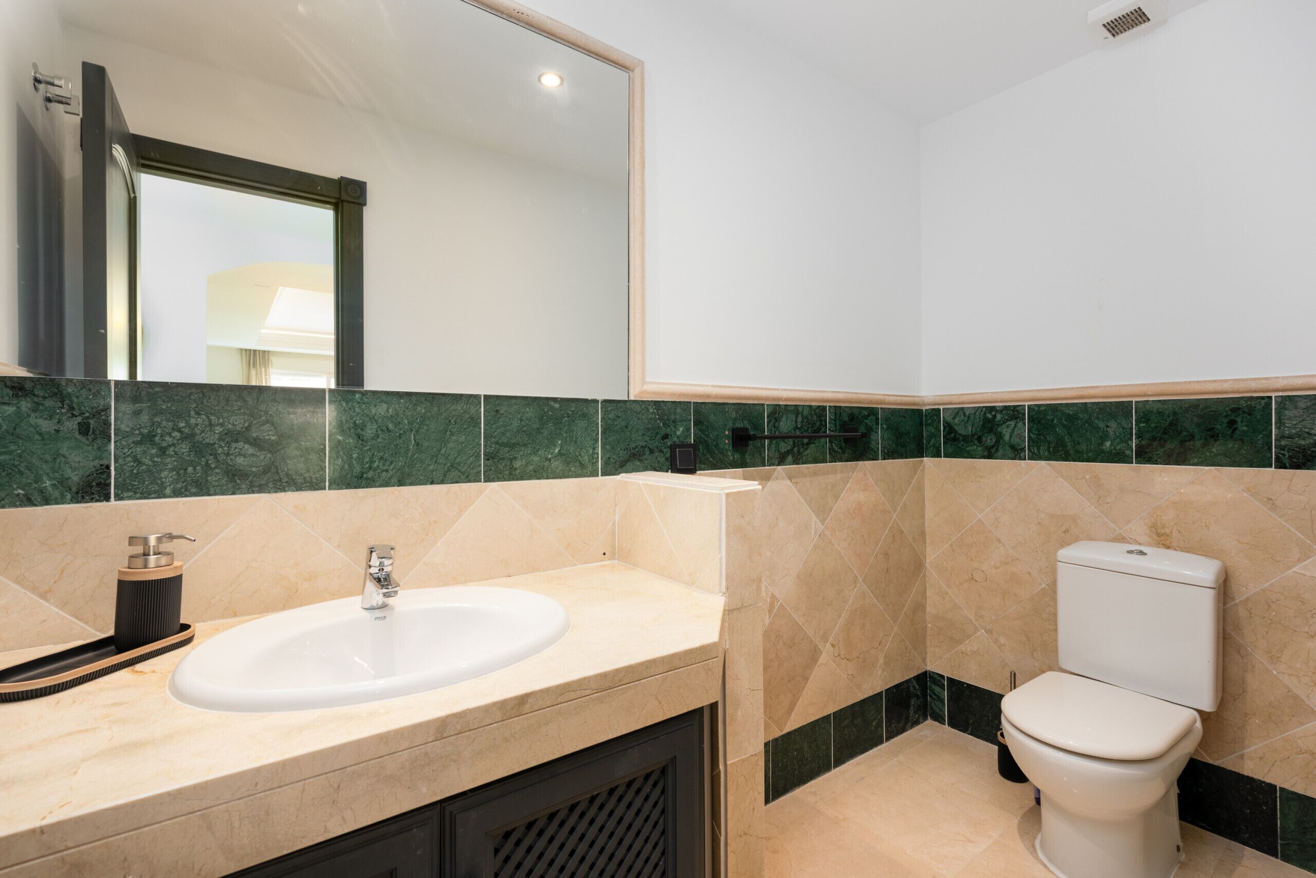Ein modernes Badezimmer mit Waschbecken, Spiegel und Toilette.