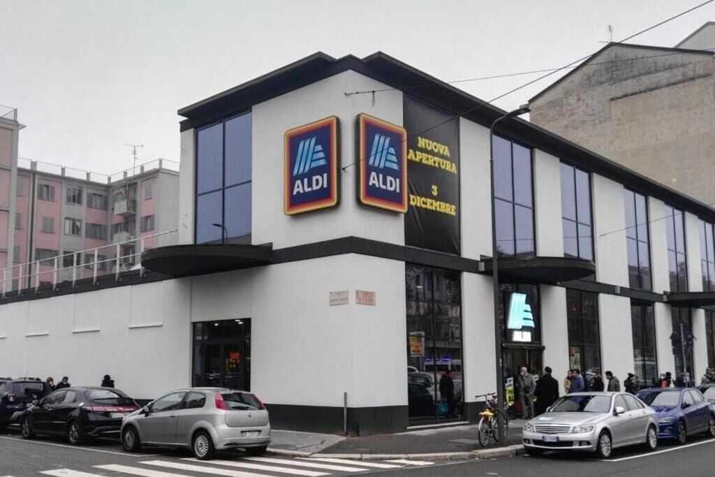 A modern building with two prominent ALDI logos on the facade, indicating a retail store.
