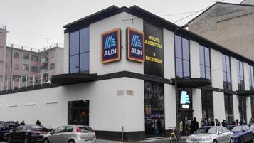 A modern building with two prominent ALDI logos on the facade, indicating a retail store.