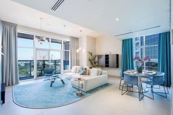A modern living room with a sofa, coffee table, and dining area with chairs.