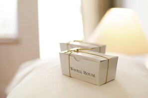 Two white boxes with gold strings tied around them, labeled "Wavell House Private Guest Lodge."