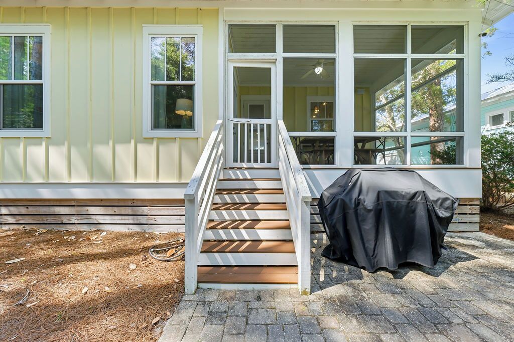 Une maison avec un porche, une table extérieure couverte et un escalier menant à l’entrée.