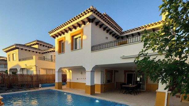 A two-story building with a swimming pool, outdoor seating, and a wooden fence. - Baron Villa With Private Heated Pool on Mar Menor (Torre-Pacheco)