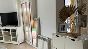 A living room with a TV on a white cabinet, a radiator, and a decorative plant. - Baron Villa With Private Heated Pool on Mar Menor (Torre-Pacheco)